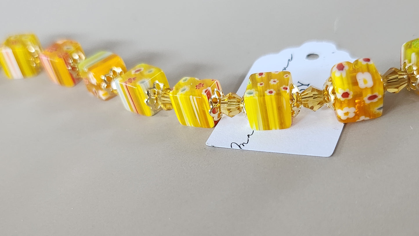 Bracelet with yellow and gold beads on a gray background