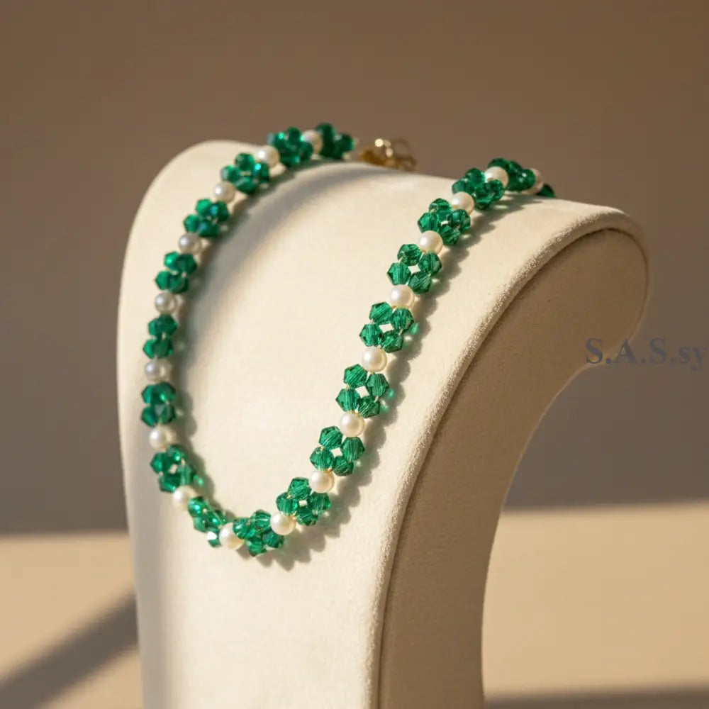 Green crystal and pearl beaded bracelet on a stand