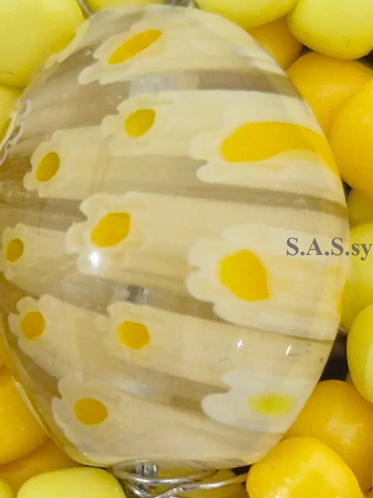 Yellow glass bead with floral pattern