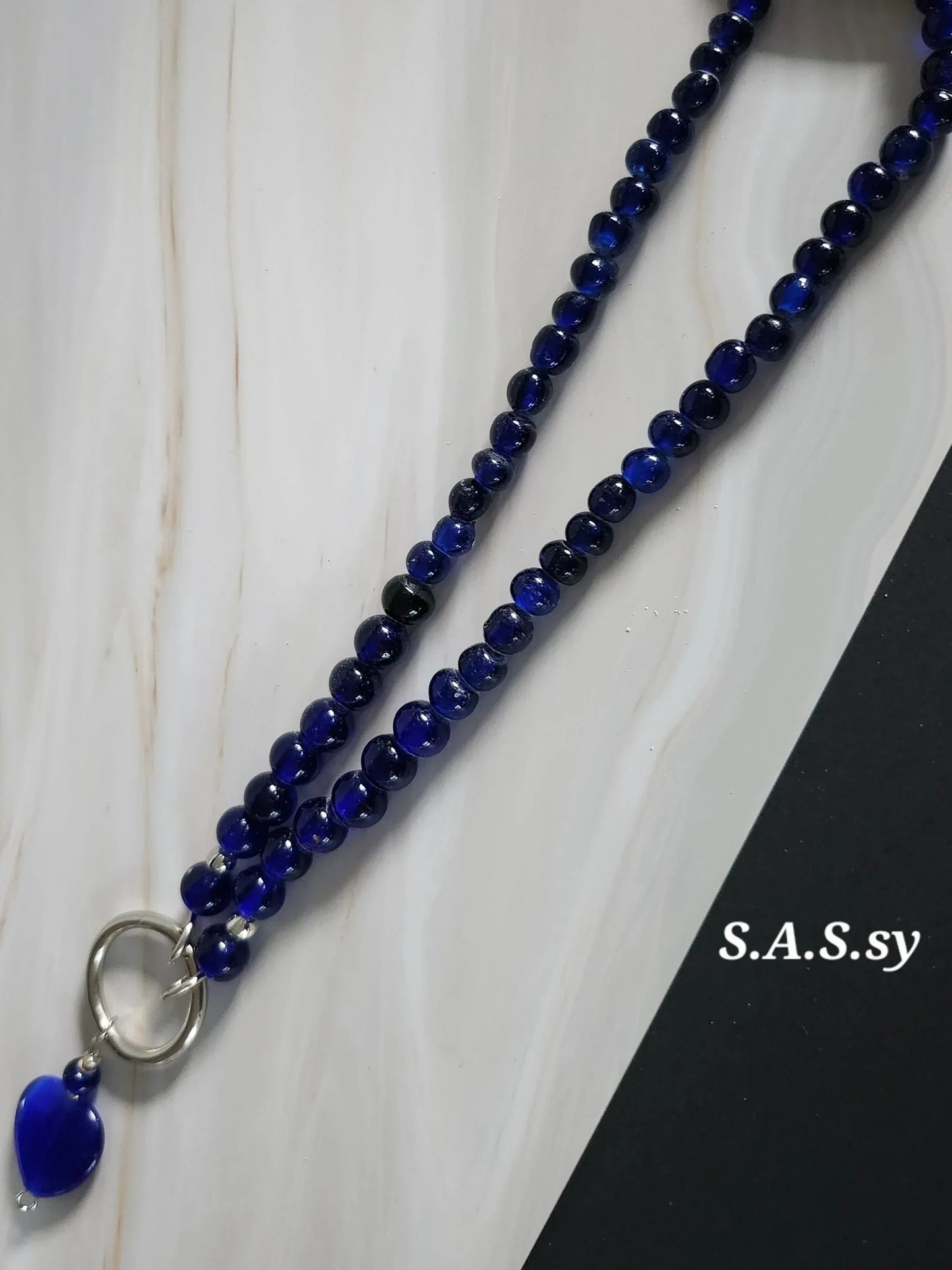 Navy glass bead necklace with a silver accent and navy heart shaped pendant 