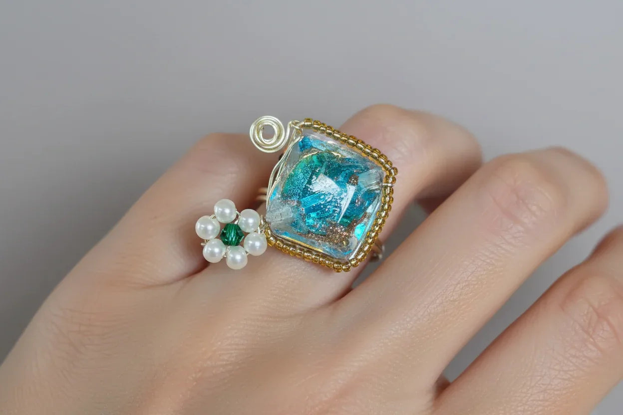 Aqua square bead with mini pearl flower wire-wrapped ring on finger