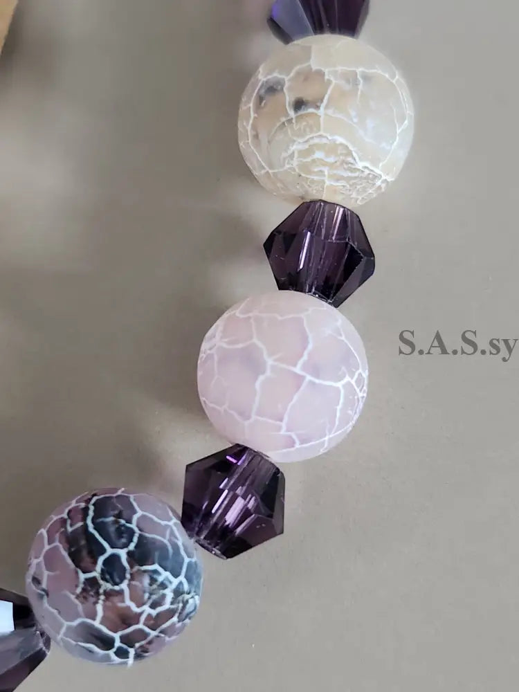 Set of decorative beads with a cracked glass design on a neutral background