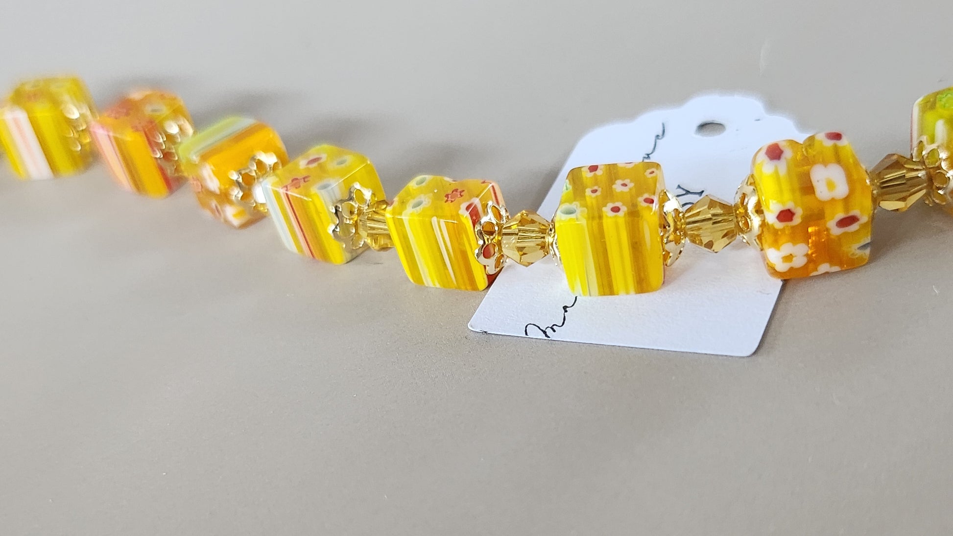 Bracelet with yellow and gold beads on a gray background