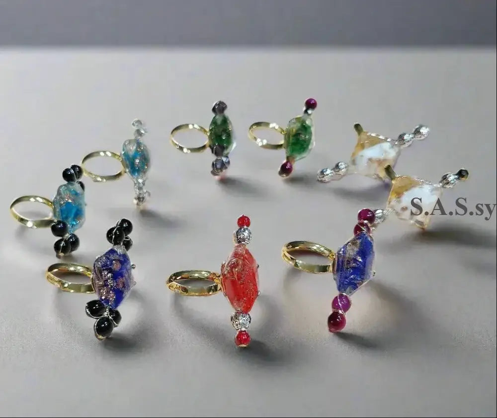 Nine vivid coloured cocktail rings on a light surface - Sassy by Sharmin Aziz 