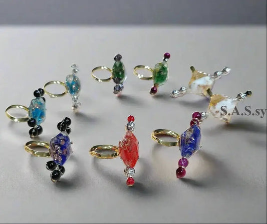 Nine vivid coloured cocktail rings on a light surface - Sassy by Sharmin Aziz 